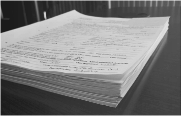 Image of a stack of documents on a board room table